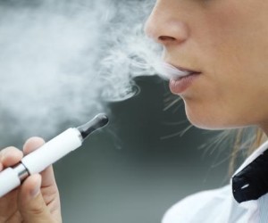 closeup of woman smoking e-cigarette and enjoying smoke. Copy space